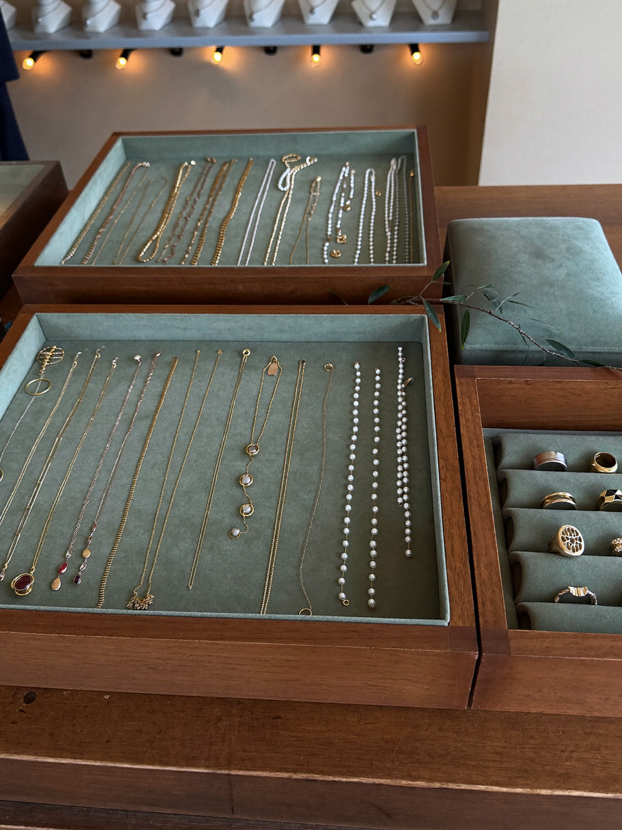The Maison Osonn counter, trays of gold-tone pieces on sage velvet
