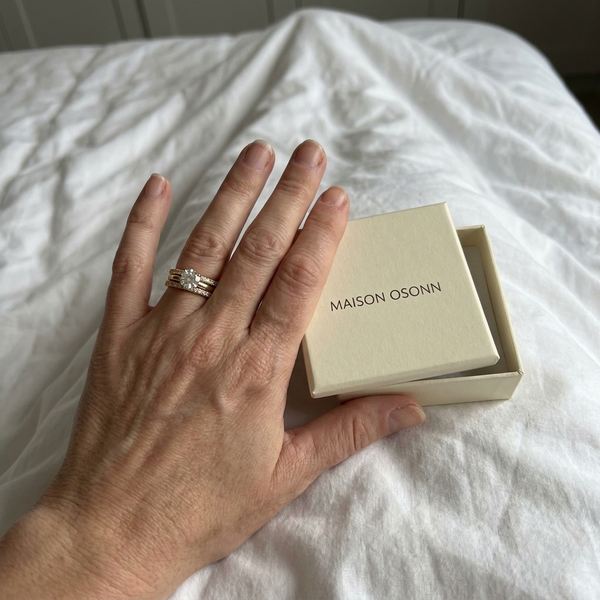 Maison Osonn Célestine Radiance Stacked Ring on a hand holding its open box