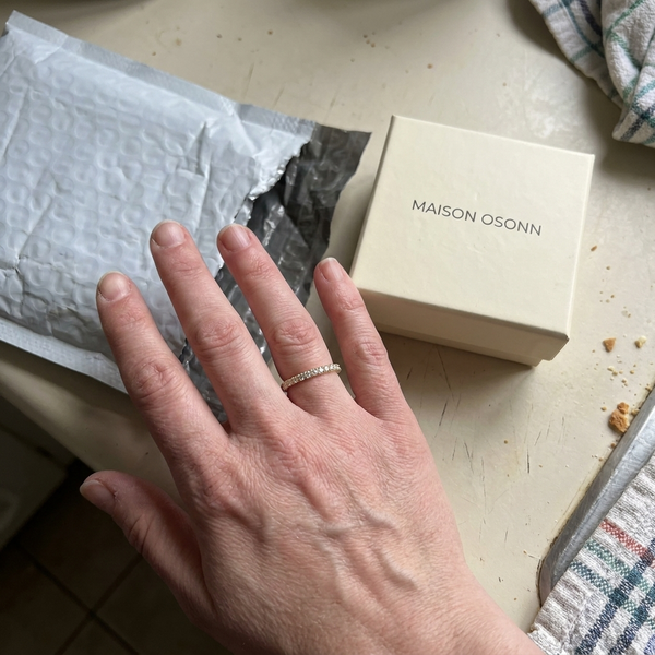 Maison Osonn Aurélie Signature Pavé Ring on a hand beside its box and mailer