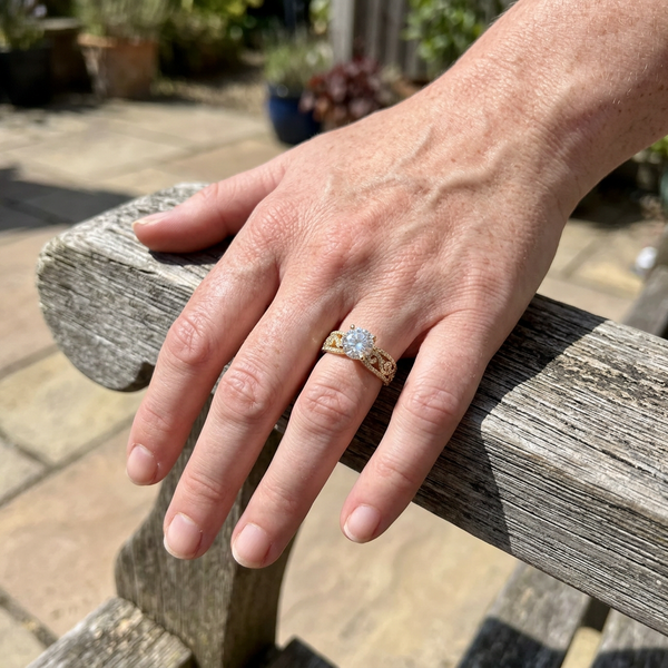 Maison Osonn Héritage Sculpted Ring on a hand resting on a garden chair